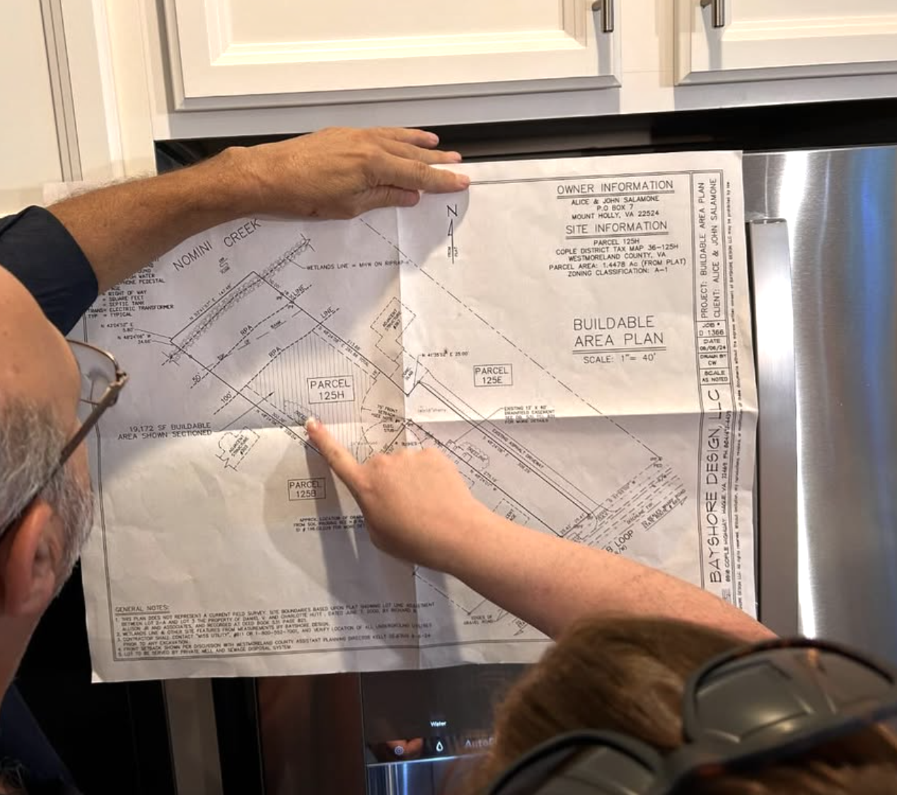 Examining and discussing the construction site blueprint and land layout.