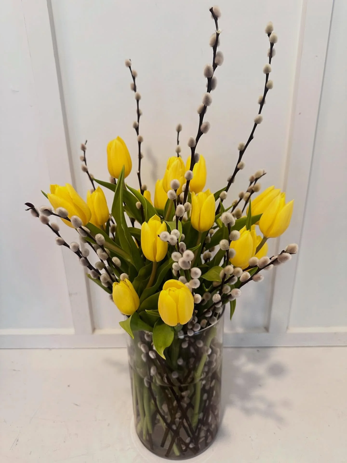 Sometimes simple is everything 💛
Bright yellow tulips + velvety pussy willow branches in a tall glass cylinder &mdash; with the stems laid out inside the vase for that extra little design detail that makes you look twice.
This is the one that makes 
