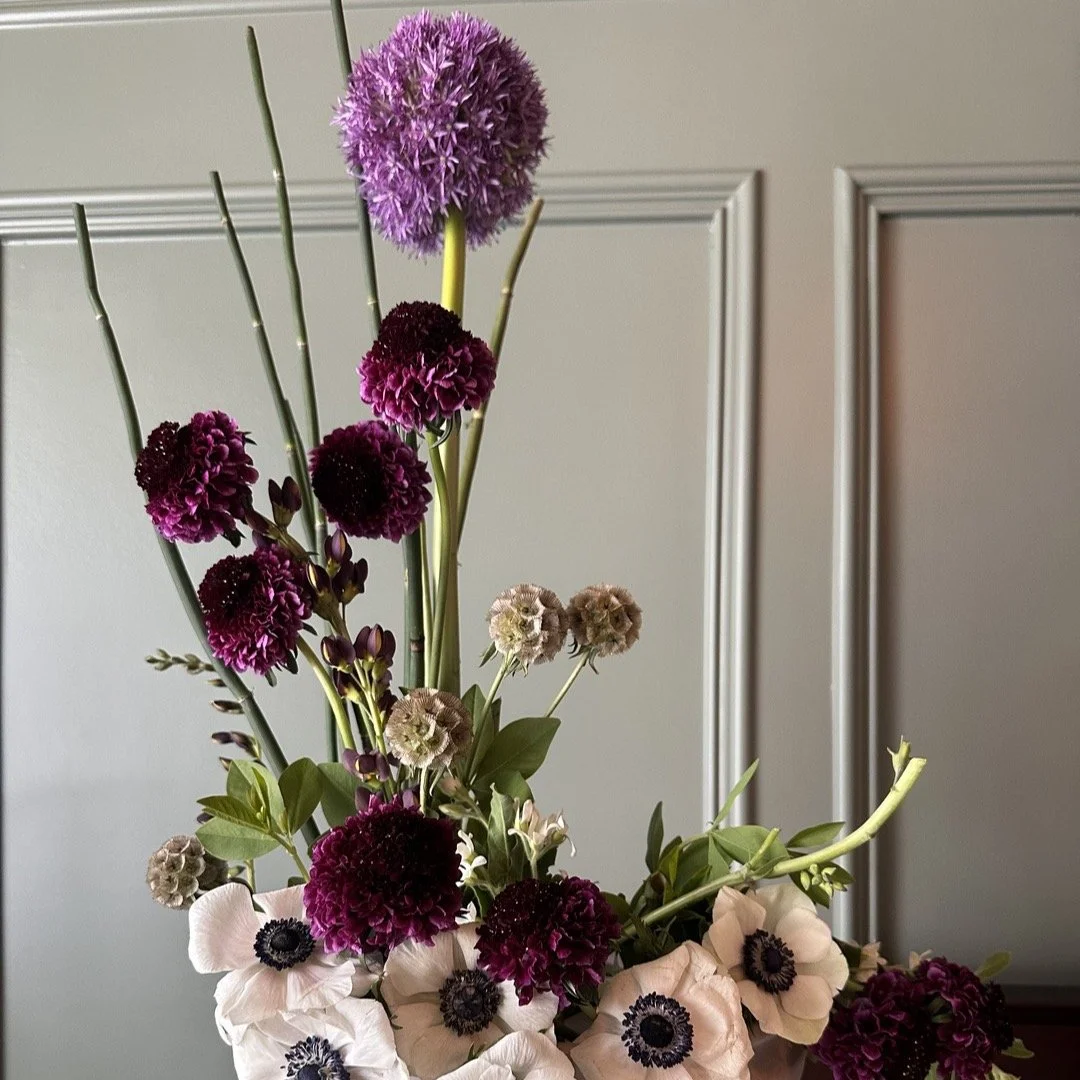 One of my favorite Spring flowers... the Allium. This arrangement in honor of it. Surrounded by
burgundy scabiosa, papery pods, and white anemones with ink-dark centers &mdash; in a blush compote.
Link in bio to order. $15 delivery across the Triangl
