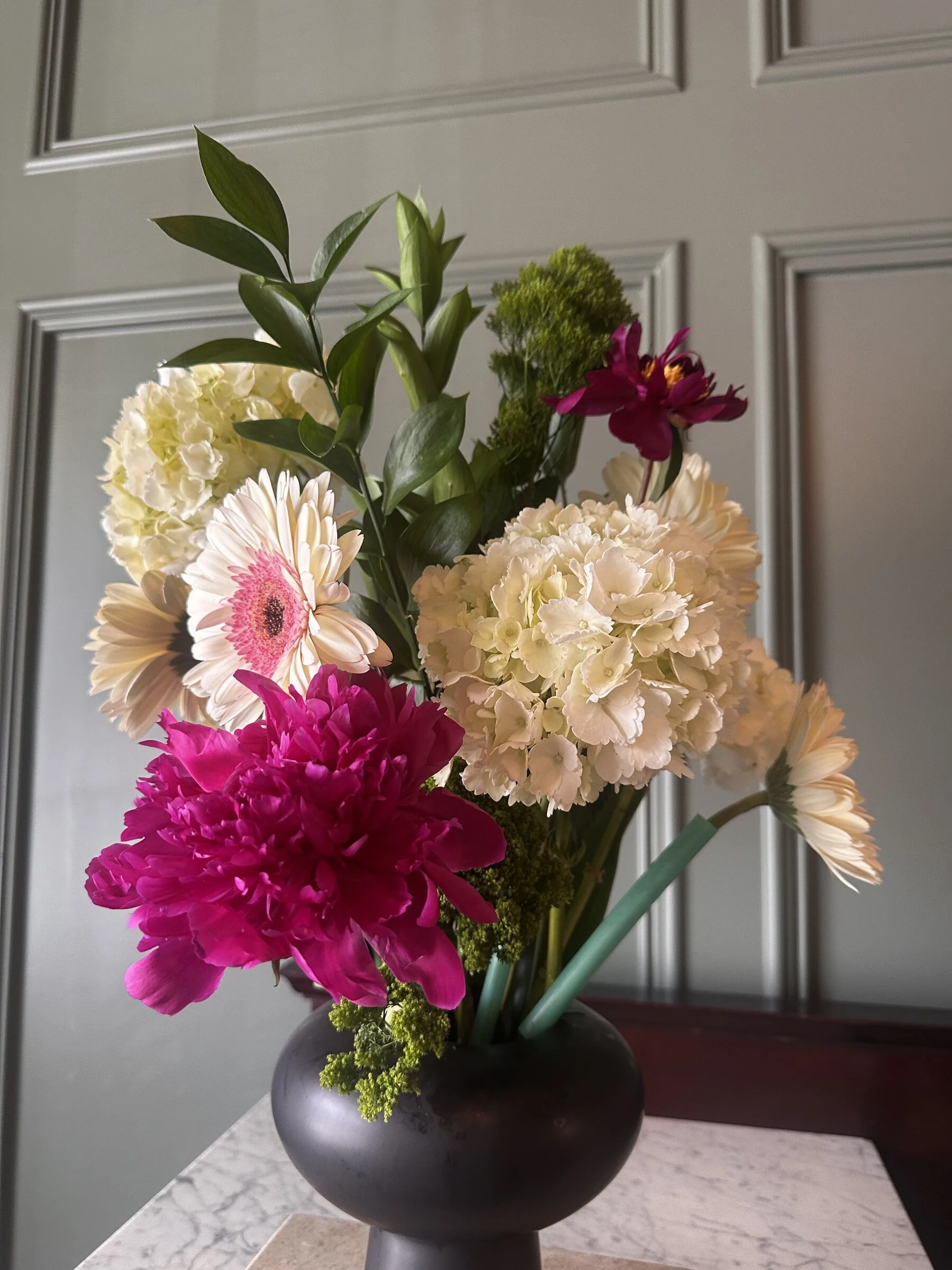 Close-up of magenta peony and blush gerbera daisy in a foam-free ikebana-inspired arrangement — Cary florist