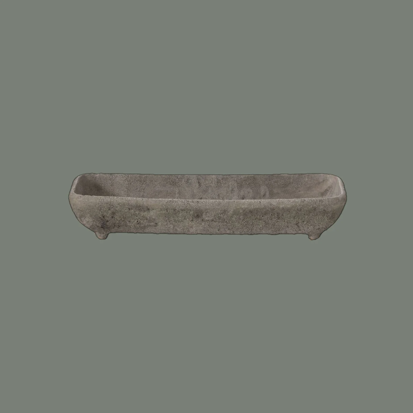 An ancient gray stone bowl, elongated with four small feet, set against a plain gray background.