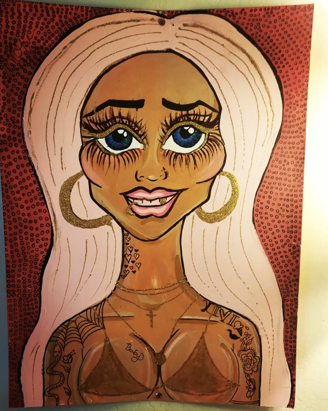 A colorful illustrated portrait of a woman with large blue eyes, long platinum blonde hair, gold hoop earrings, and tattoos on her shoulder and chest. She has a warm smile and wears layered necklaces.
