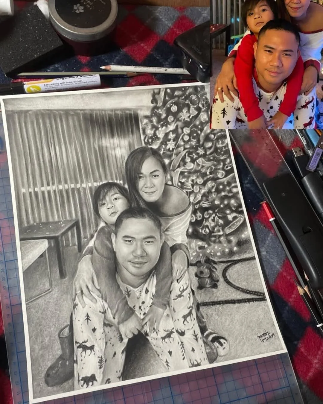 A realistic black-and-white pencil drawing of a family with two children, a mother and father, sitting close together. The background features Christmas decorations and a tree. A small, grayscale photo of the same family in color is positioned above 