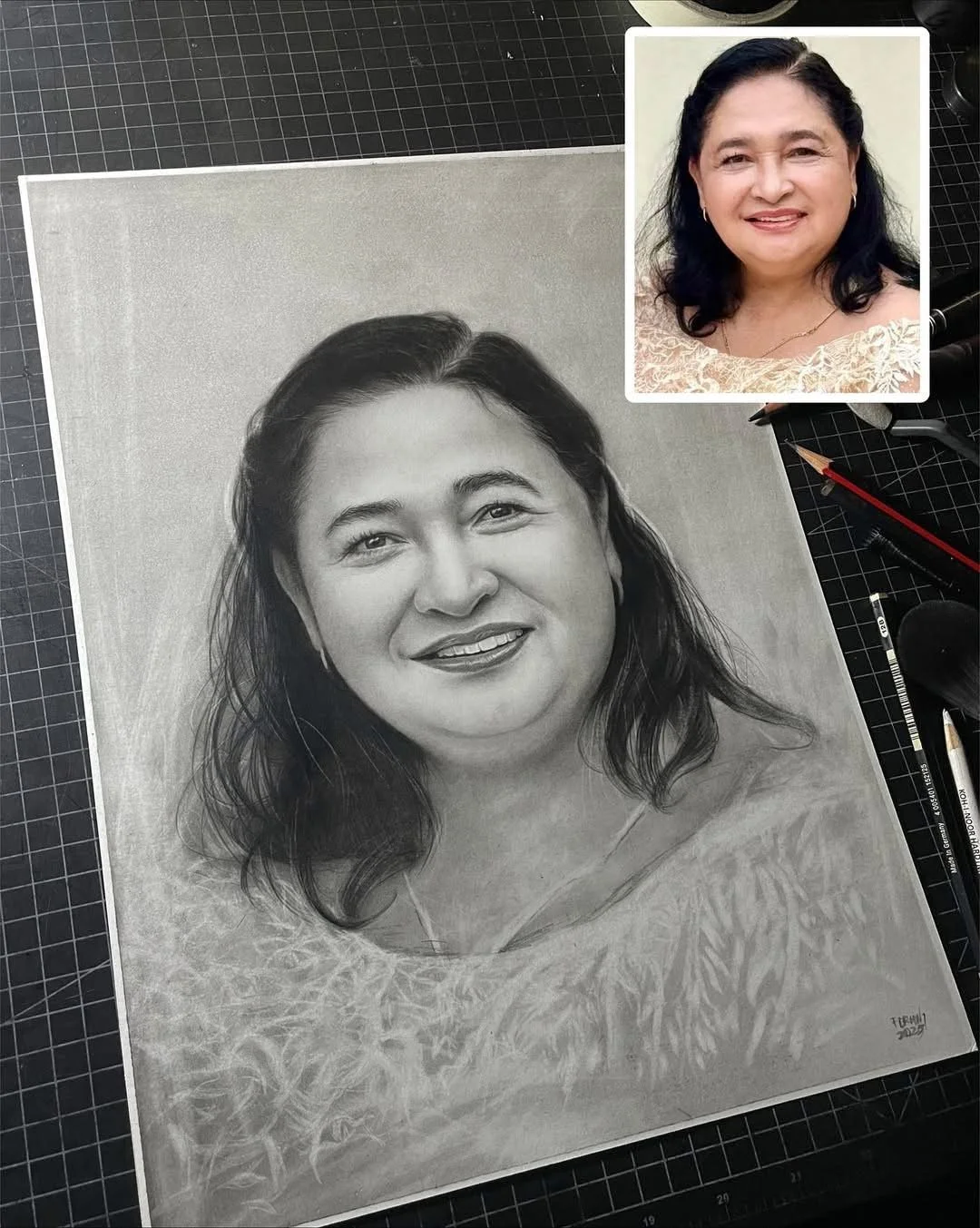 A detailed grayscale pencil drawing of a woman with dark, shoulder-length hair, smiling, with a softly textured background. A small photo of the same woman with a different background is inset in the top right corner.