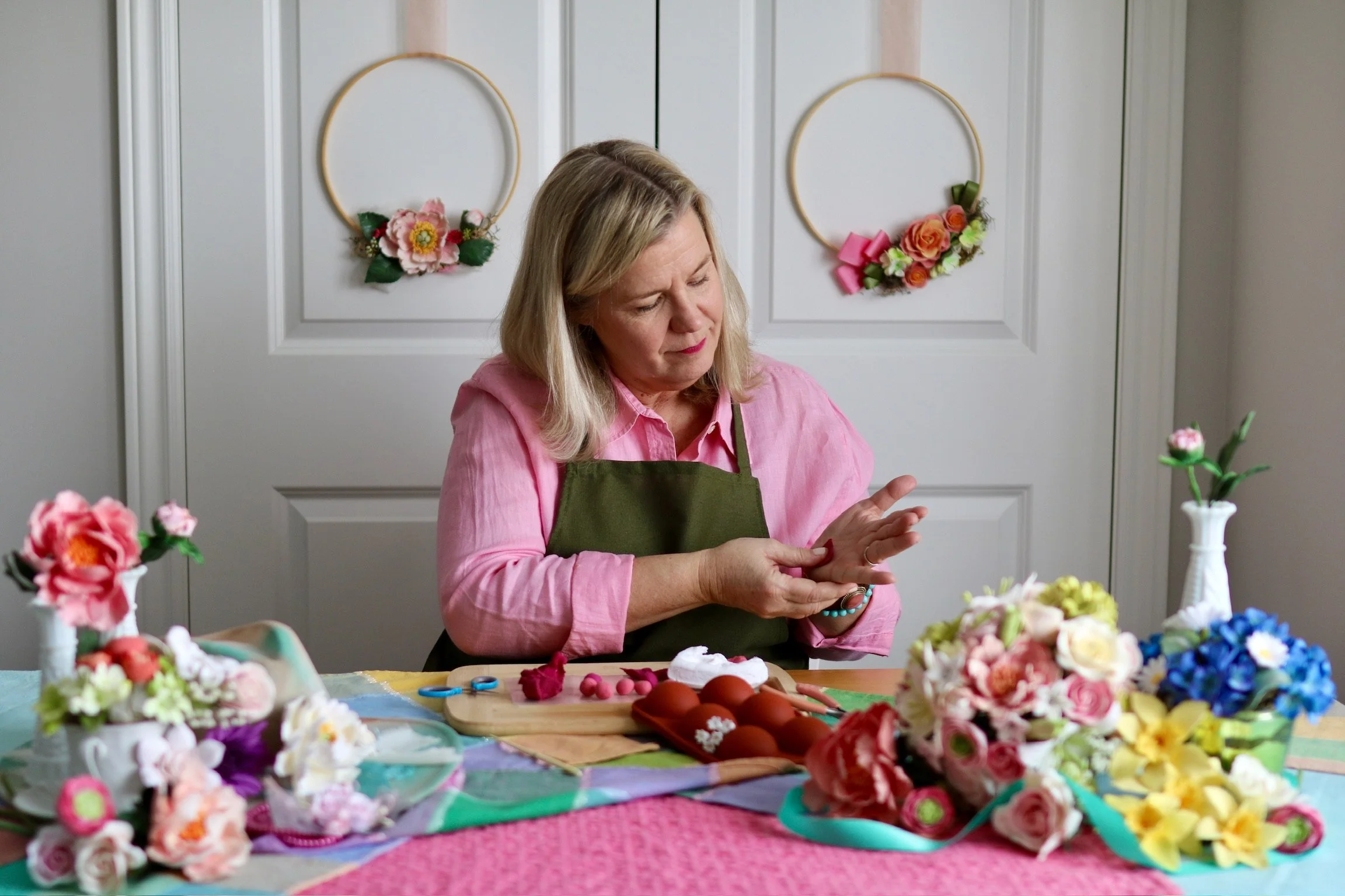 Clay flower artist, Tracey Paul creating flower petals by hand to create one-of-a-kind blooms. Petals and flowers on a work table.