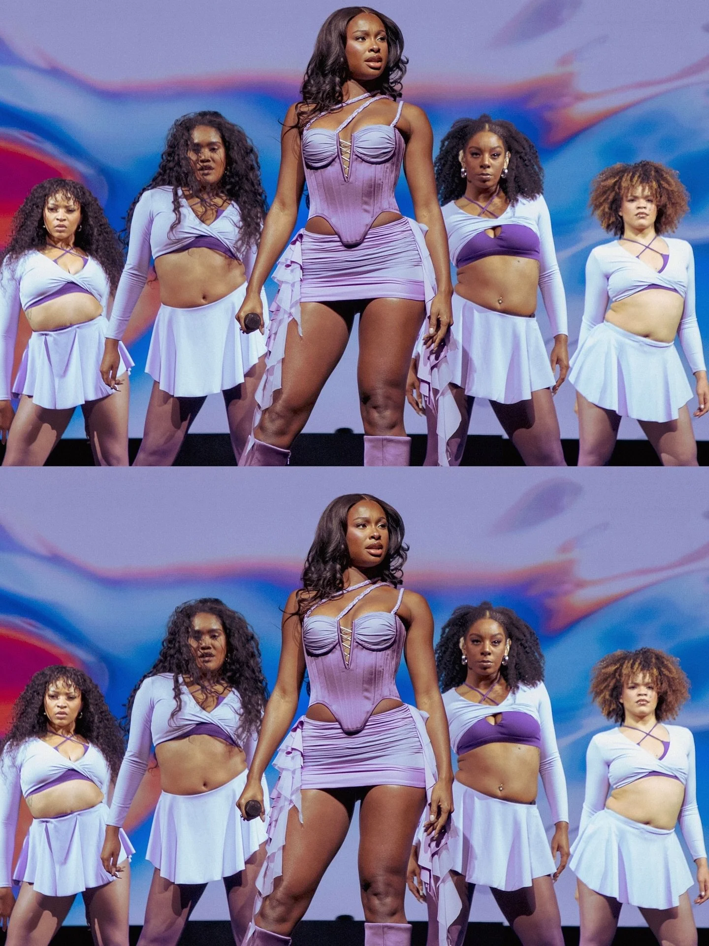 A group of women performing on stage, dressed in purple and white costumes with a colorful backdrop.