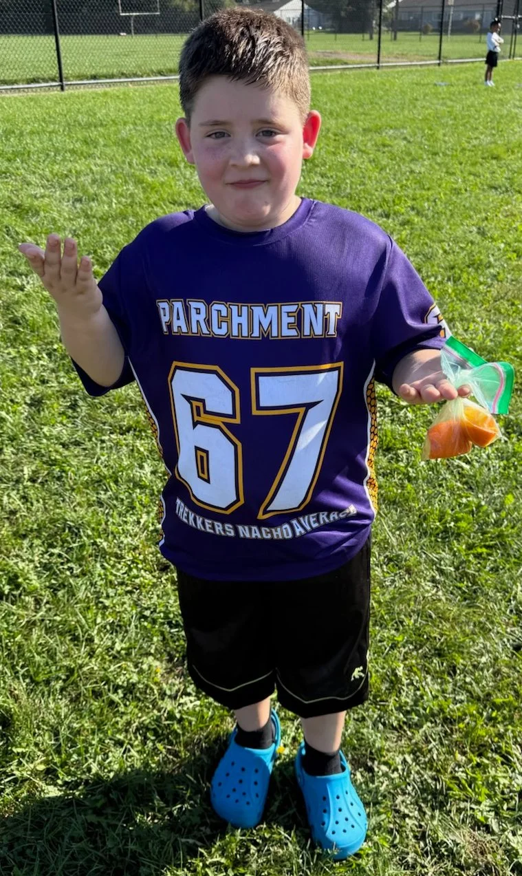 Chuck and Bev's grandson wearing his team's Trekker's-sponsored jersey. The jersey has the number "67" and the text "Trekker's Nacho Average" below it.