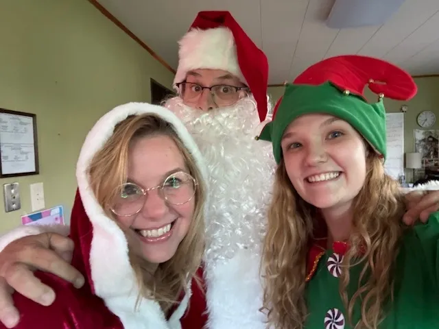 Chuck is dressed as Santa with his helper elves at his side
