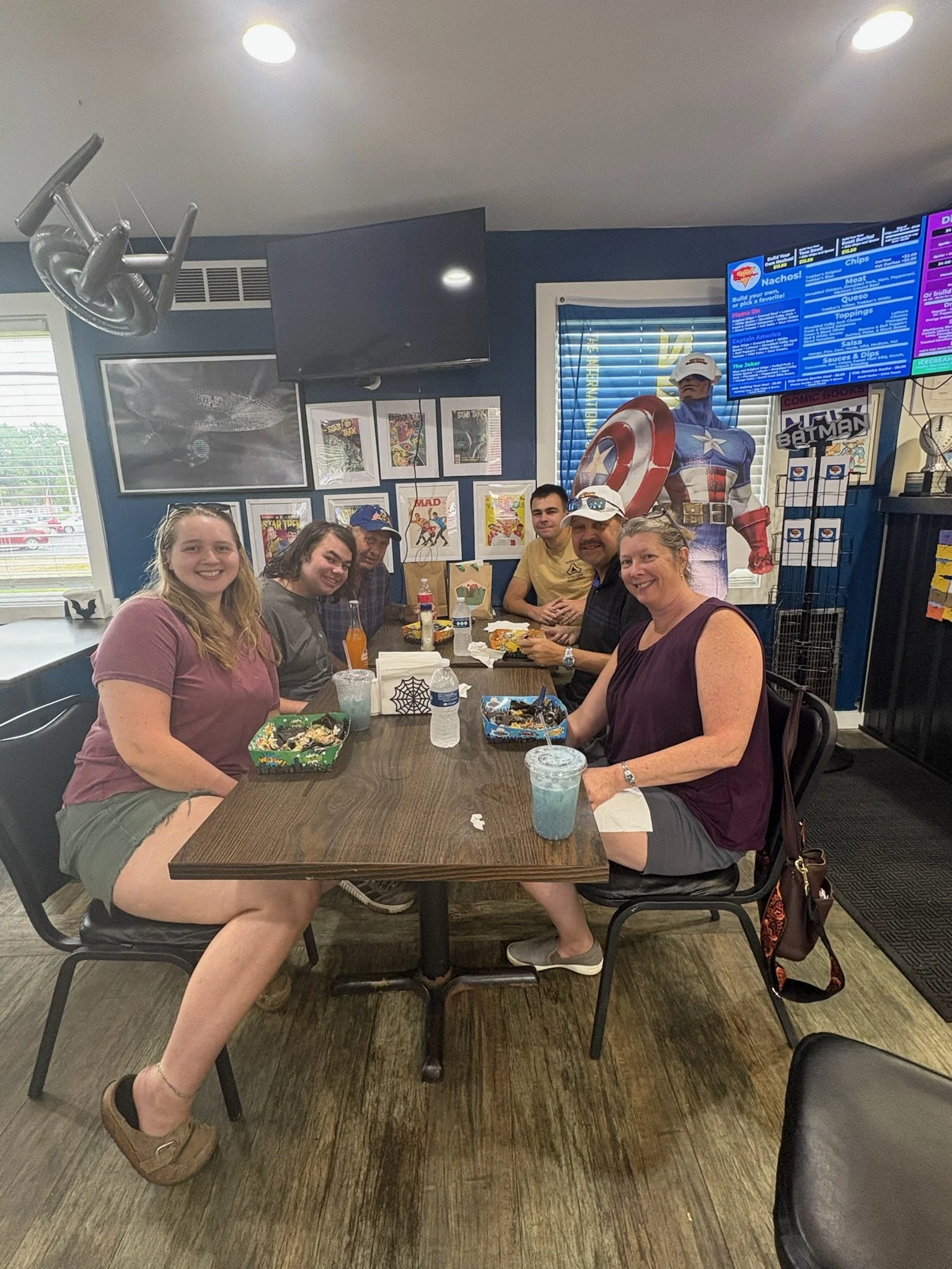 Chuck and Bev's family sitting at tables inside Trekker's Nacho Average, sharing a meal of nachos and drinks.