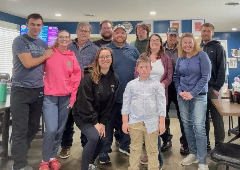 Chuck and Bev posing for a group photo with their family, including their kids, grandkids, and relatives.
