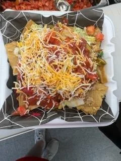 A delicious bowl of nachos including shredded cheese, salsa, lettuce, and Trekker's Original Chips.