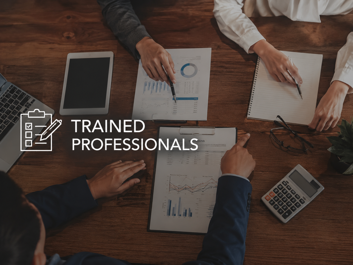 Business professionals working at a conference table with documents, a calculator, a tablet, and a laptop, with the overlay text 'Trained Professionals' and an icon of a checklist on a clipboard.