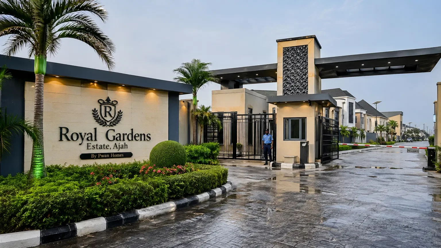 Entrance gate to Royal Gardens estate in Ajah, featuring well-maintained greenery, a security guard, and modern architectural design.