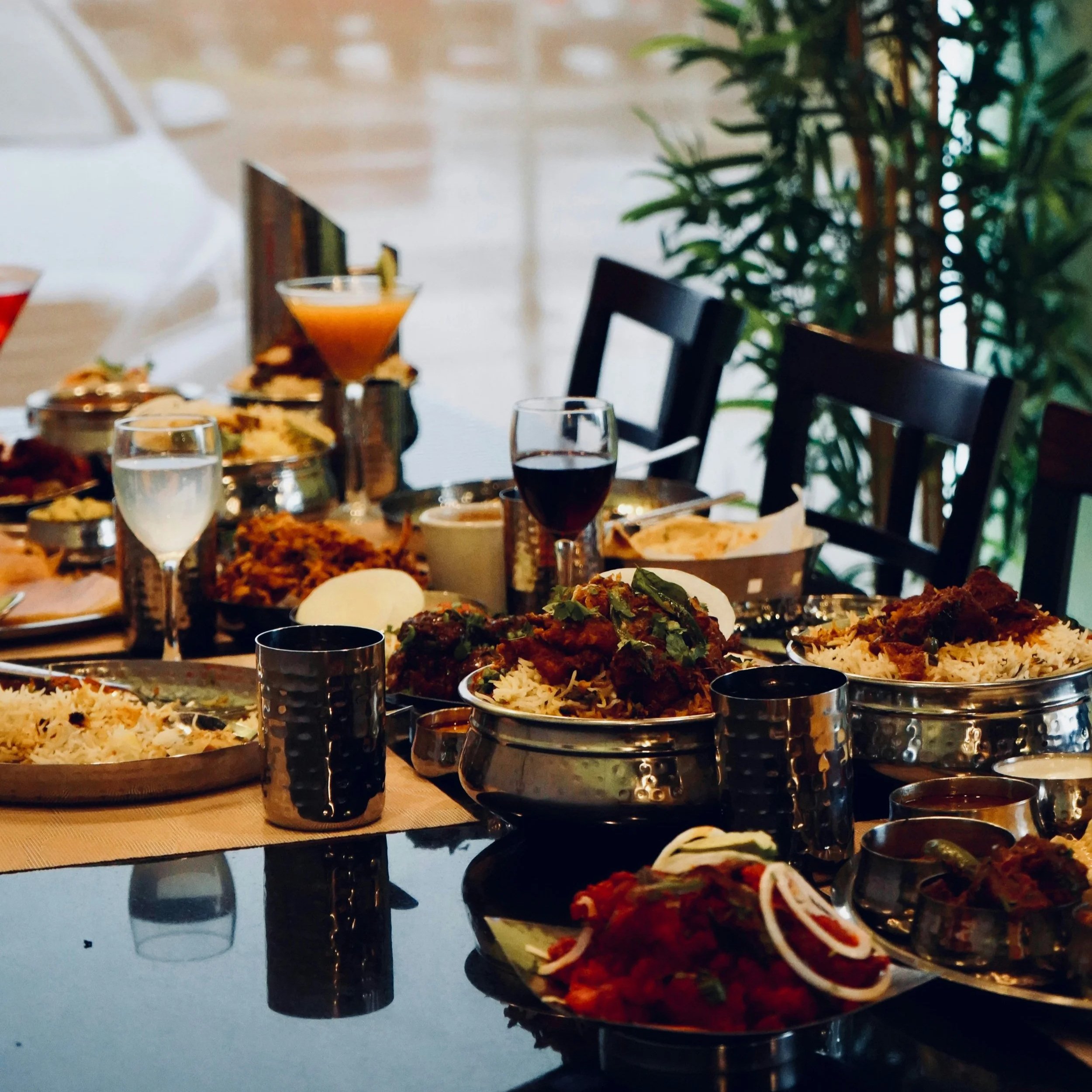 Dining table set with a colorful catered meal and drinks.