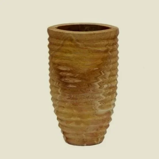 A piece that captures the relaxed, sun-washed elegance of Mediterranean living. Crafted from natural stone, its ribbed texture and softly tapered silhouette echo the organic, timeworn beauty found in homes along the Amalfi Coast and Ibiza. Effortless