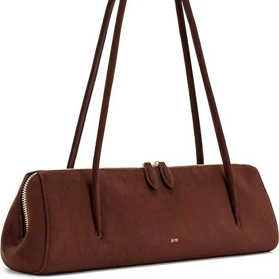 Quietly modern with a distinctly continental ease, it embraces the east–west silhouette trend. Its elongated form sits neatly under the arm, giving that effortless, almost Parisian sense of “thrown on but considered.” The soft faux suede finish adds 