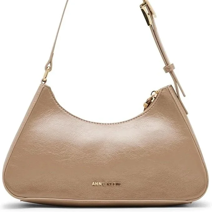 The Anne Klein east-west shoulder bag is a study in modern restraint. Its elongated silhouette sits effortlessly under the arm, while the truffle or black tones echo a distinctly European palette; rich, versatile, and never overstated. 