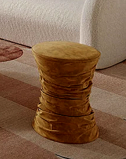 A ruched velvet ottoman with an adjustable design, adding texture and flexibility to a room that likes to keep things layered and a little unexpected. Its softly gathered surface gives it a sculptural feel, another small detail that helps a space rea