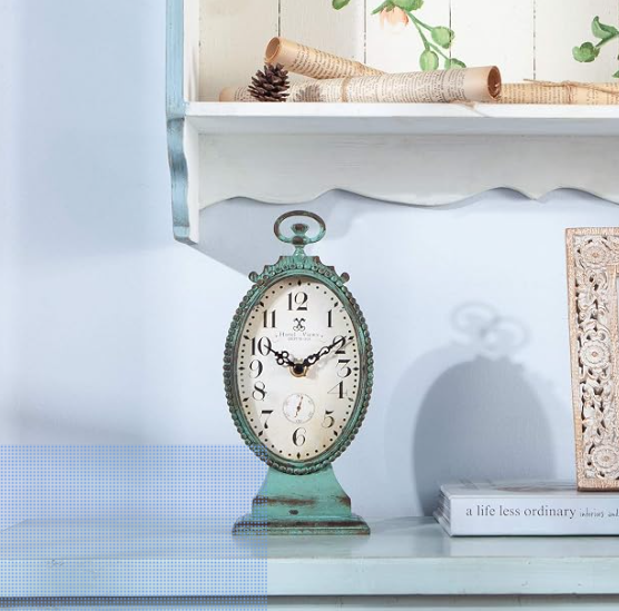
With its graceful oval silhouette and softly distressed teal finish, this vintage-inspired table clock captures the charm of a French country home. Whether placed on a mantel, bookshelf, bedside table, or bathroom vanity, it brings a subtle touch of