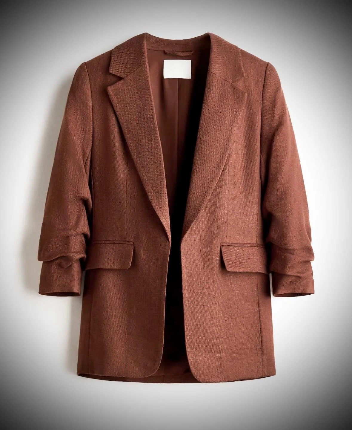 Tailored ease with a feminine edge. This fitted jacket in a soft viscose blend features sharp notched lapels, subtle shoulder structure, and softly gathered 3/4 sleeves for a modern silhouette. Flap pockets add a classic touch, while the open, no-fas