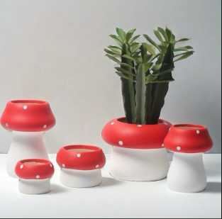 Handmade ceramic flower pot shaped like a cute, whimsical mushroom. Its playful form and charming details make it a delightful home for small plants, adding a fun eclectic touch to any windowsill or shelf.