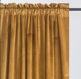 Rich velvet curtains in a warm mustard gold, adding depth and a saturated pop of color that eclectic rooms lean on to feel layered rather than flat. Against prints like leopard or tiger, they act as a grounding, textural note that ties the palette to