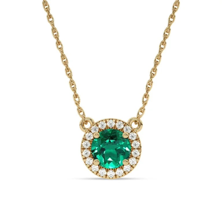 A vibrant emerald at the center, framed by a radiant halo of diamonds. Set in warm yellow gold, the contrast feels rich. The color balanced by light, presence softened by refinement.
The round silhouette keeps it classic, while the emerald brings qui