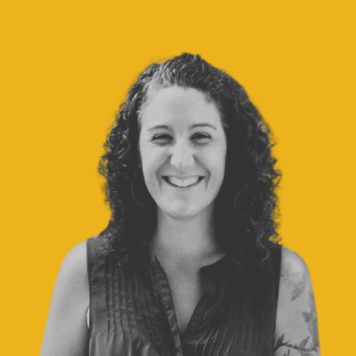 Portrait of a smiling person with long, curly hair.