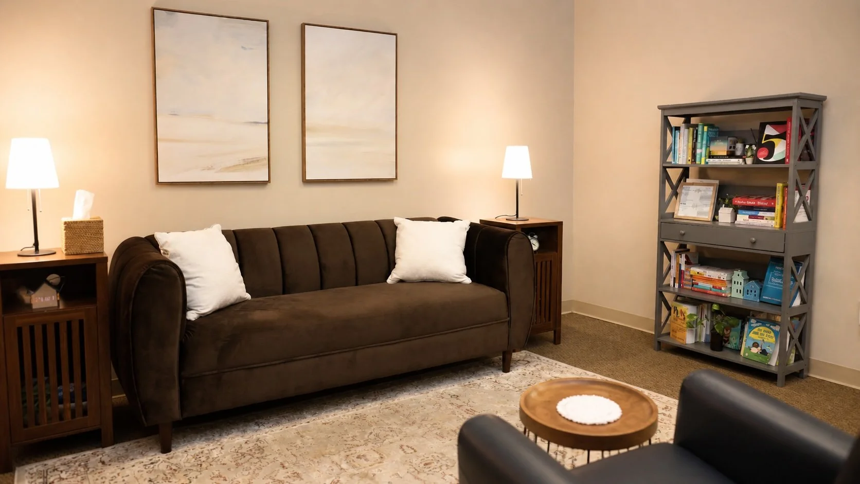 Therapy office in Westlake Village with brown sofa, bookshelf, and warm lighting