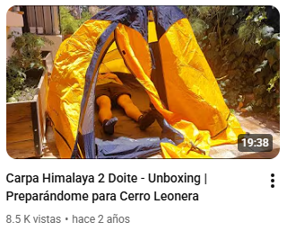Una tienda de campaña Himalaya 2 Dóite de color amarillo y negro, con un niño acostado dentro.