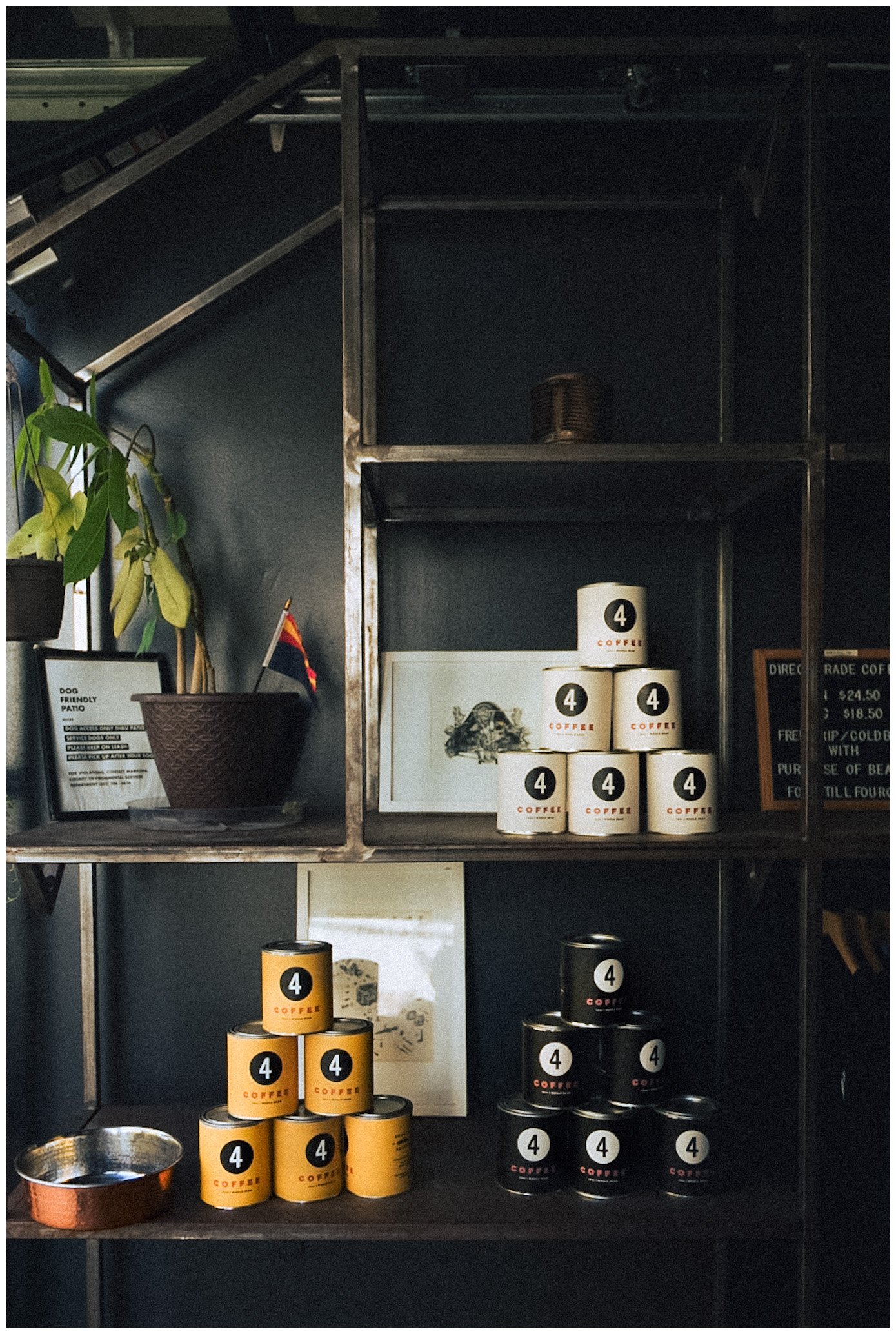 Shelves displaying coffee cans, framed prints, and a potted plant.