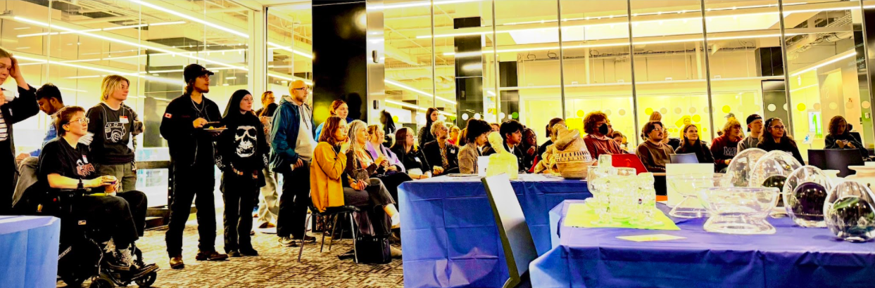 Attendees of a conference, both seated and standing.