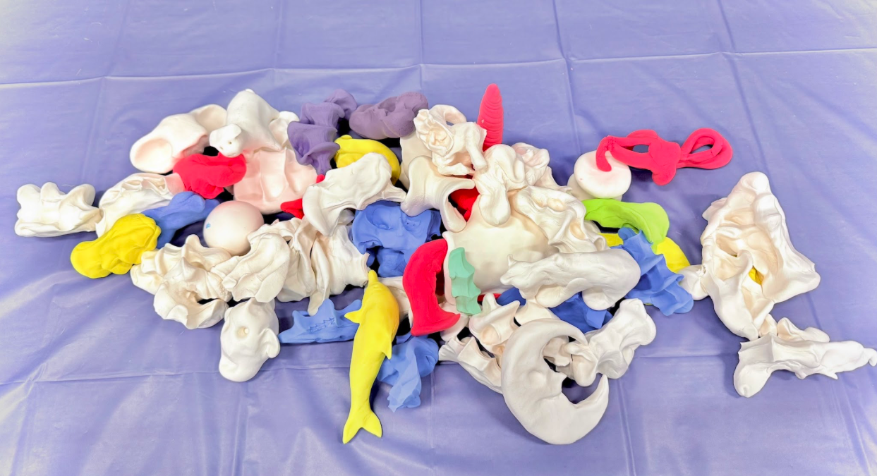 A sculpture made up of small hand-molded clay sits on a table.  This sculpture was created spontaneously by participants at the pop-up event.