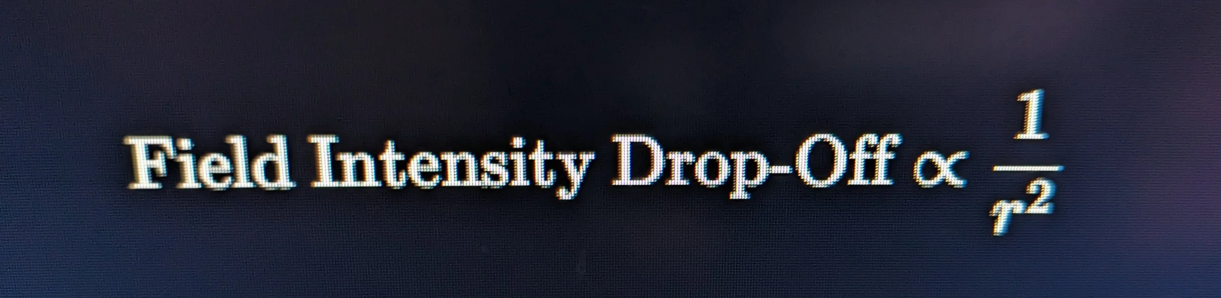 Close-up of a computer screen displaying a scientific formula involving field intensity drop-off, with Greek letter alpha and a squared variable p.