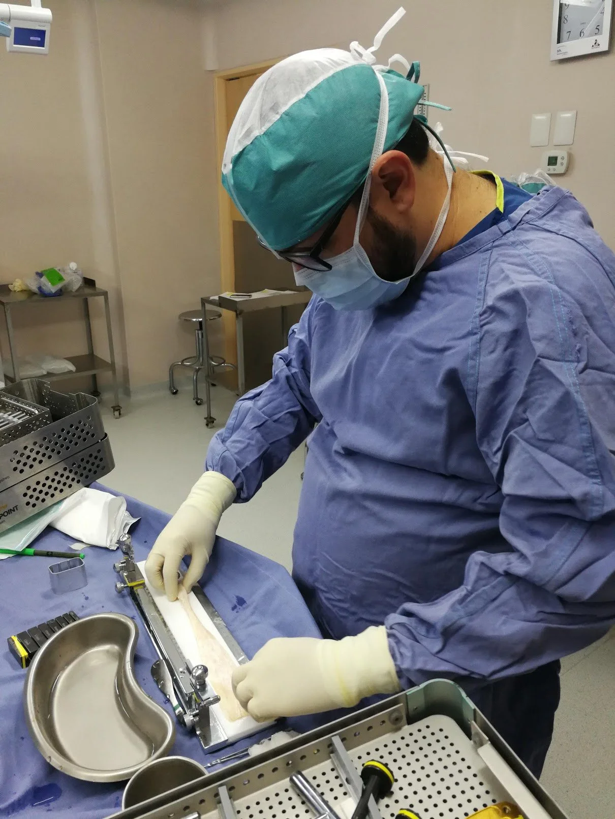 Médico en ropa quirúrgica trabajando en un procedimiento en un hospital.