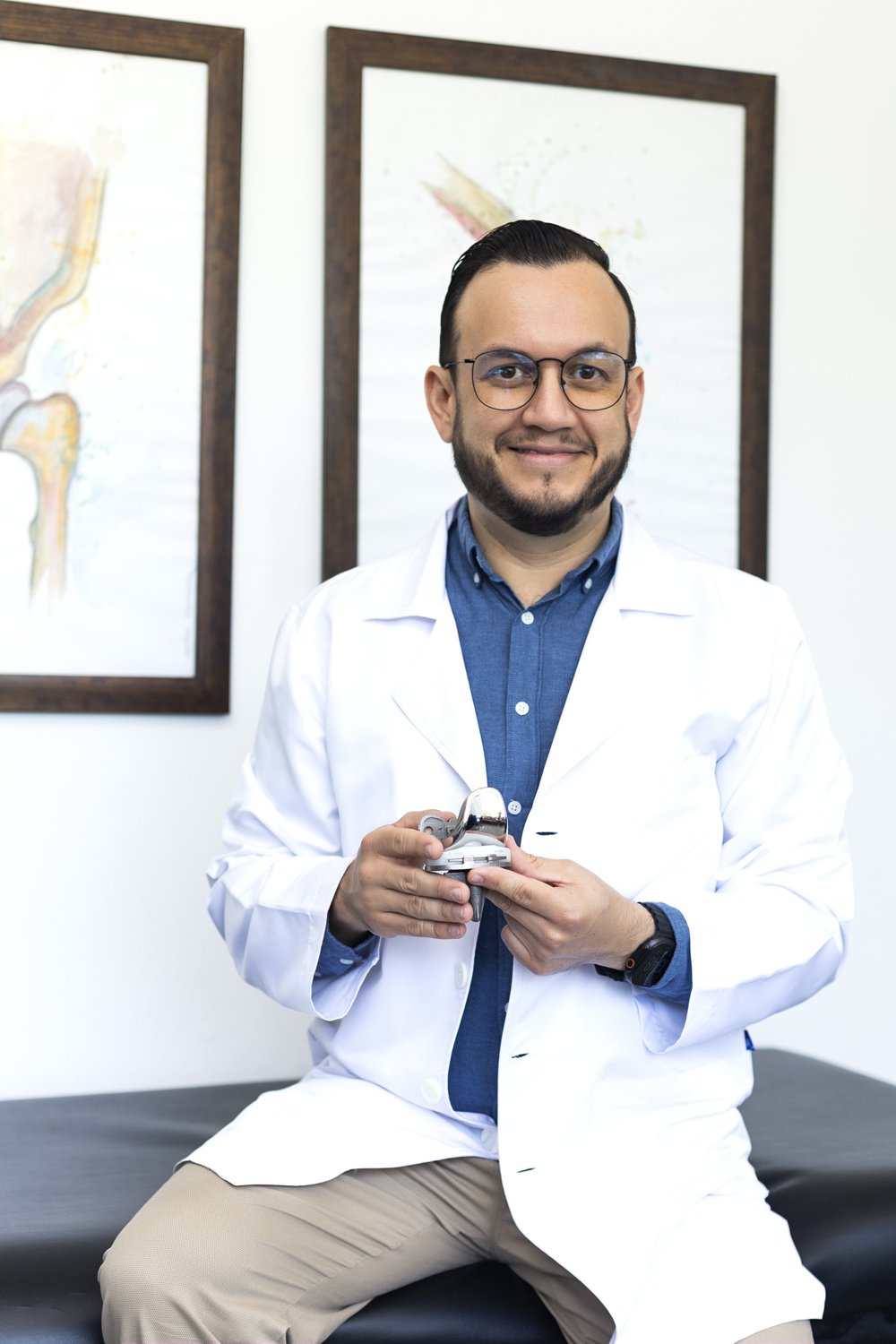 El Dr. Israel Romo muestra un componente de prótesis articular en su consultorio en Guadalajara