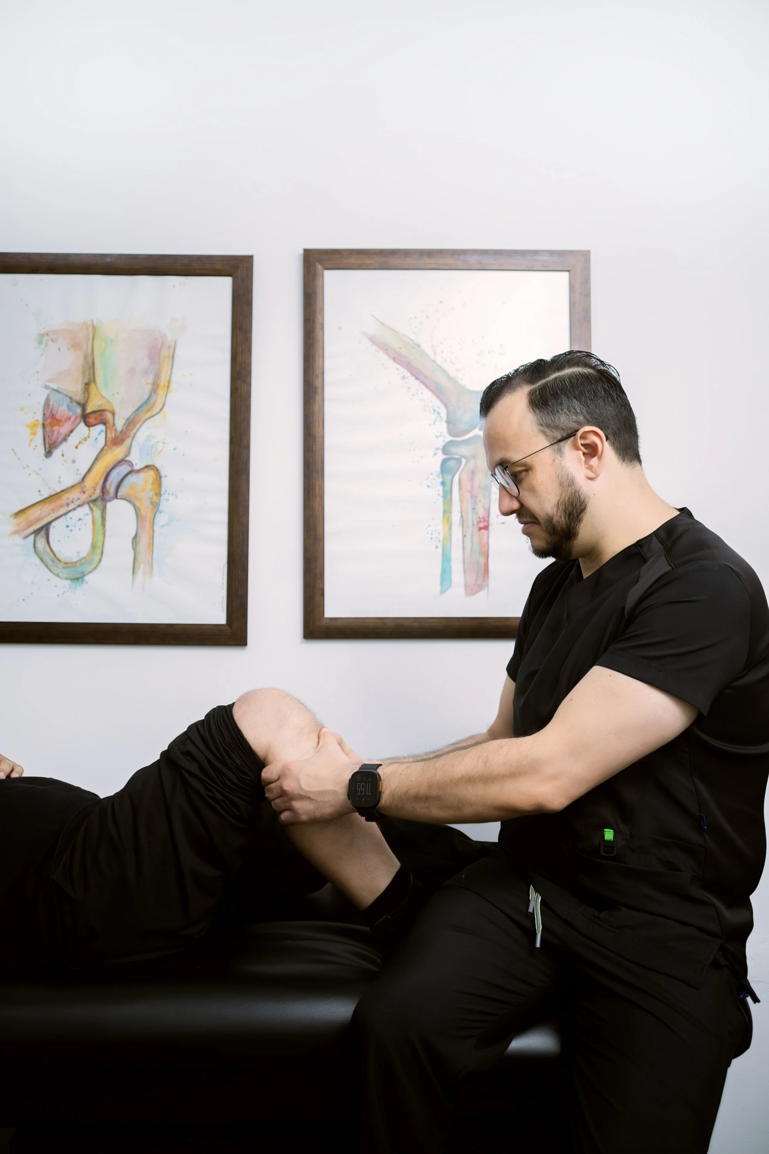 El Dr. Israel Romo ortopedista revisando la rodilla de un paciente en su consultorio