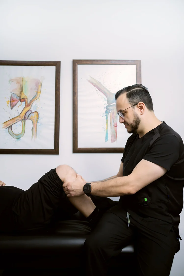 El Dr. Israel Romo revisando una rodilla en su consultorio