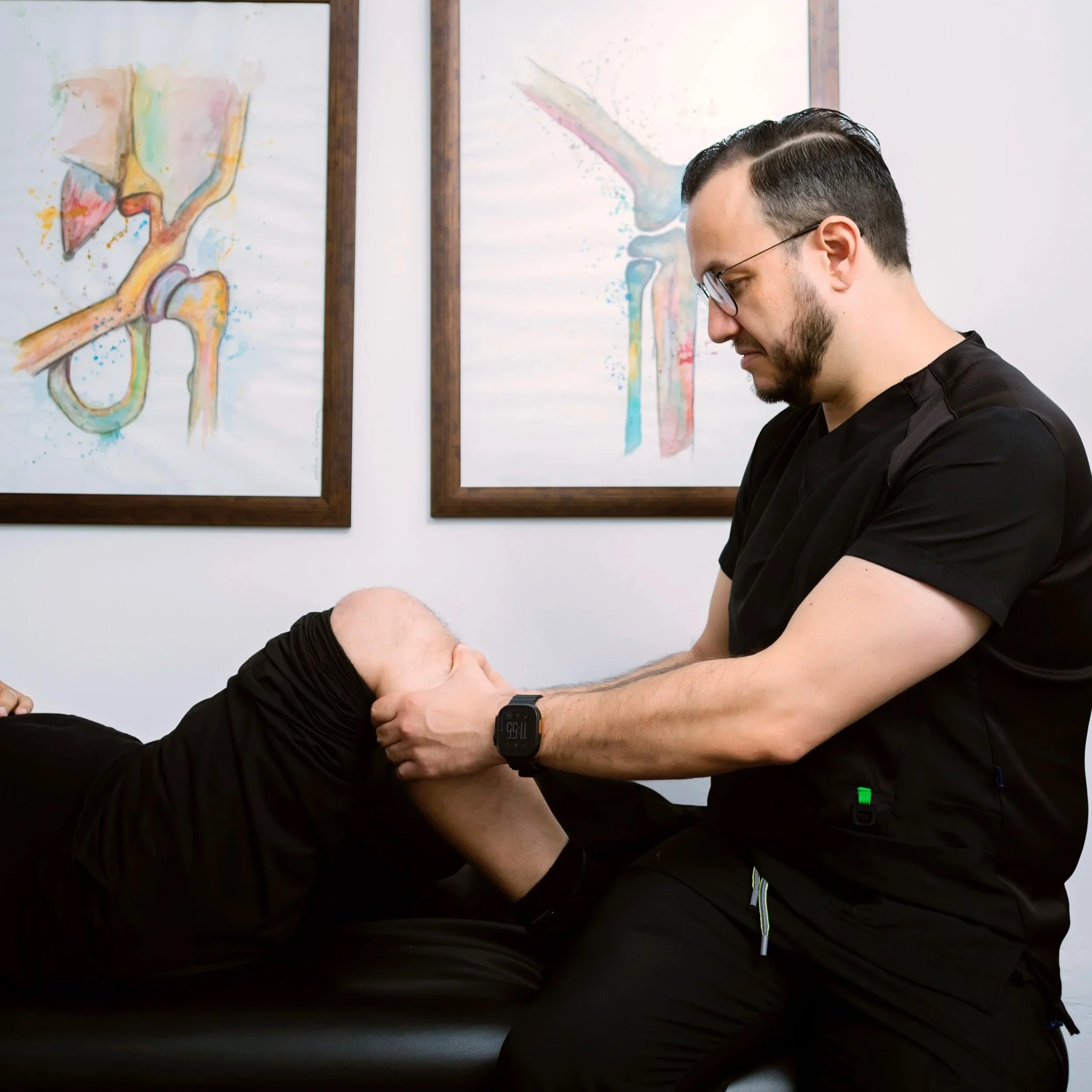 El Dr. Israel Romo especialista en ortopedia realizando maniobras de exploración física en una rodilla en su consultorio