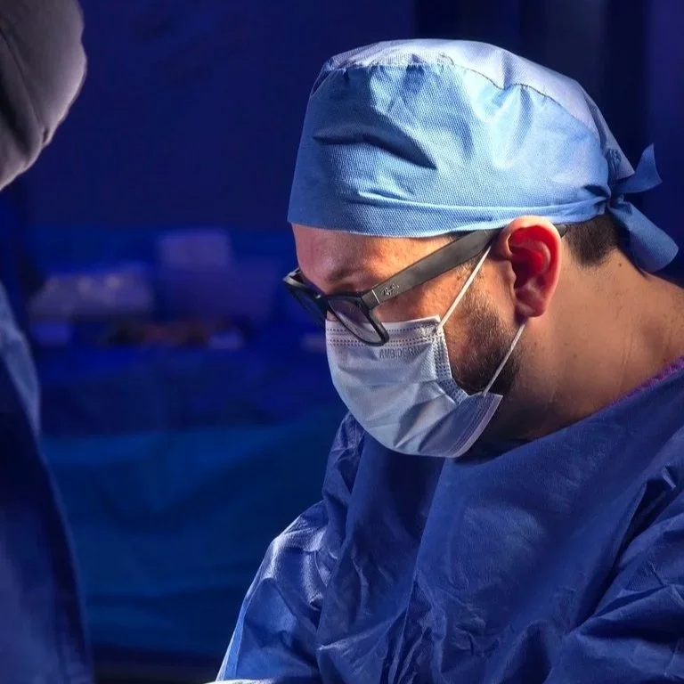 El Dr. Israel Romo, cirujano de rodilla usando un gorro, gafas y mascarilla en un quirófano durante una operación de rodilla