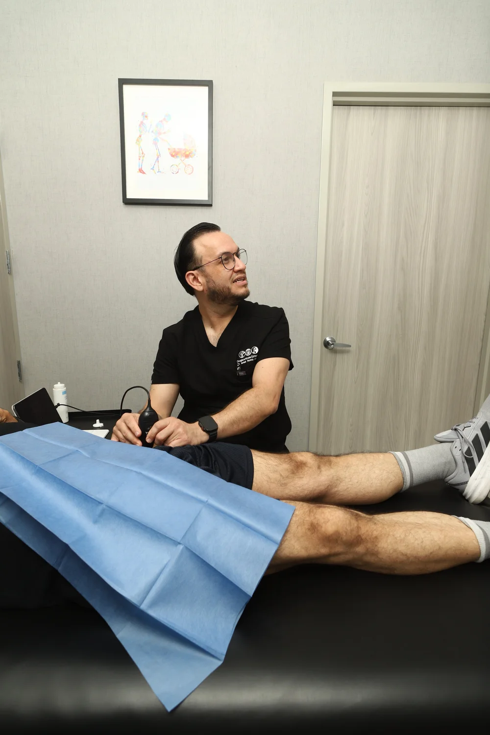 El Dr. Israel Romo con el transductor de ultrasonido durante una valoración de cadera en su consultorio