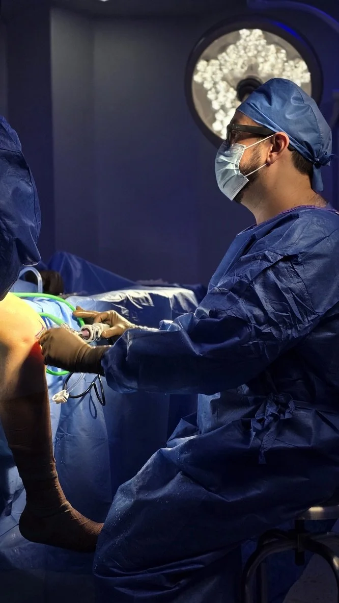 Cirujano en una sala de operaciones realizando una cirugía de rodilla