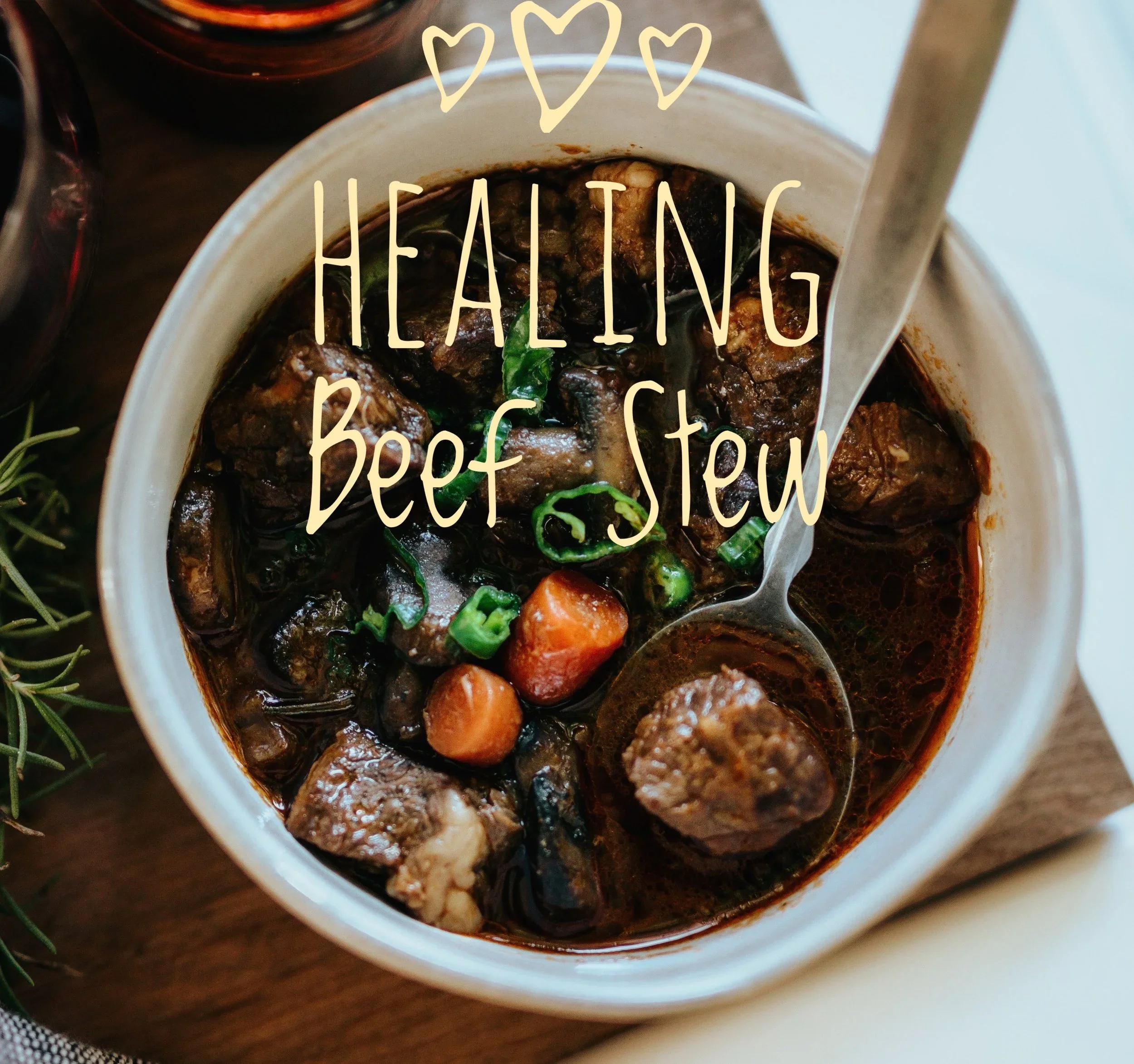 A cup of beef stew with chunks of beef, carrots, potatoes, and green herbs in a rich dark sauce.