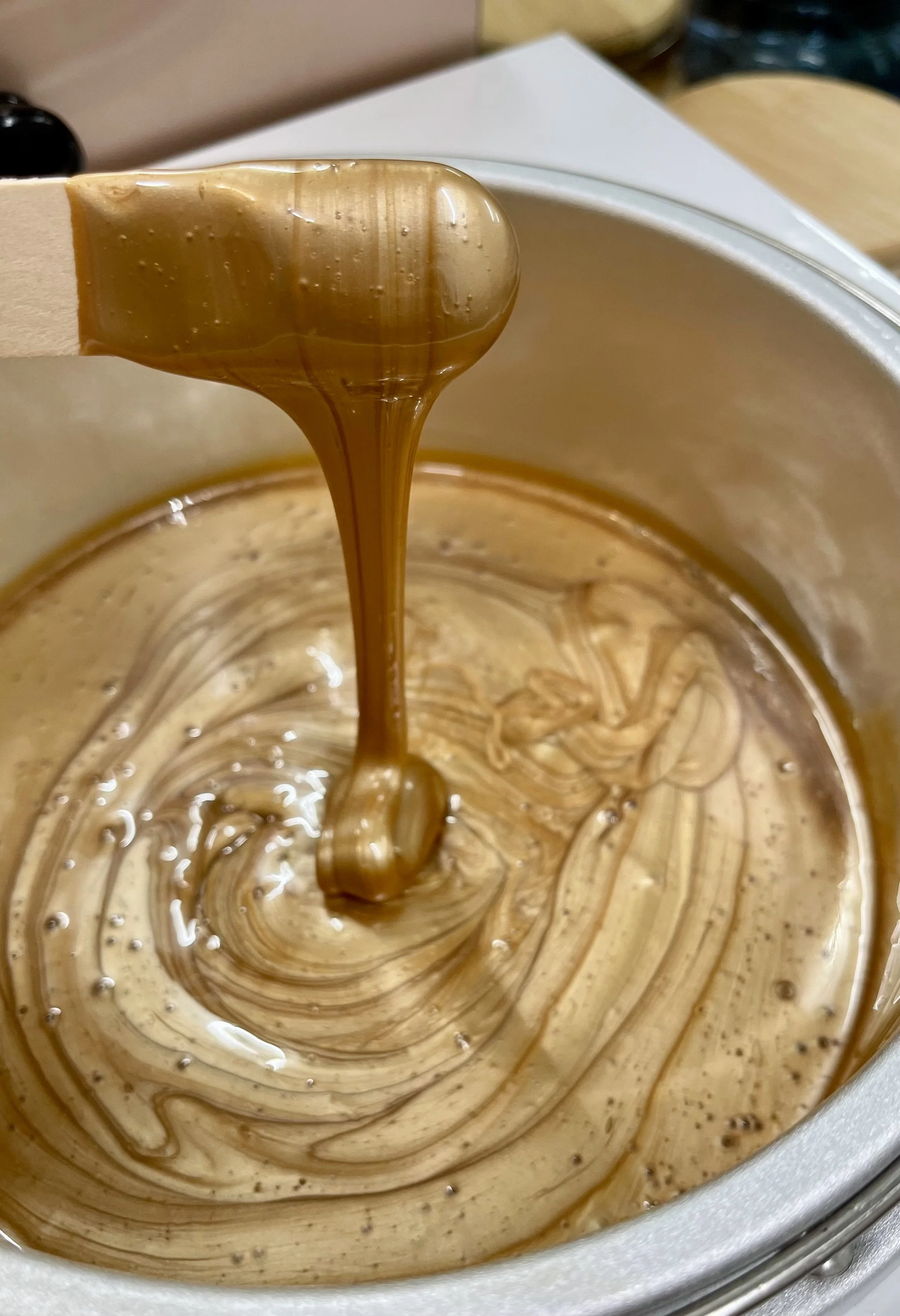 Hot fudge being poured into a bowl of ice cream.