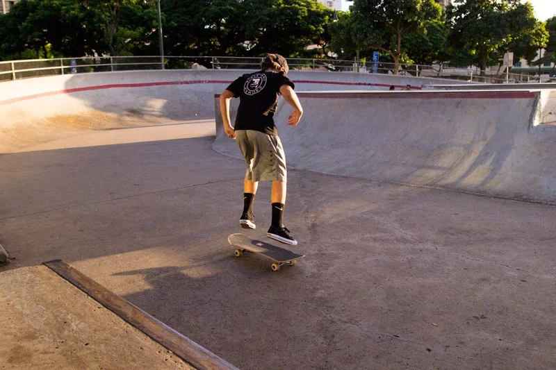 A person skateboarding in a skate park during the daytime.
