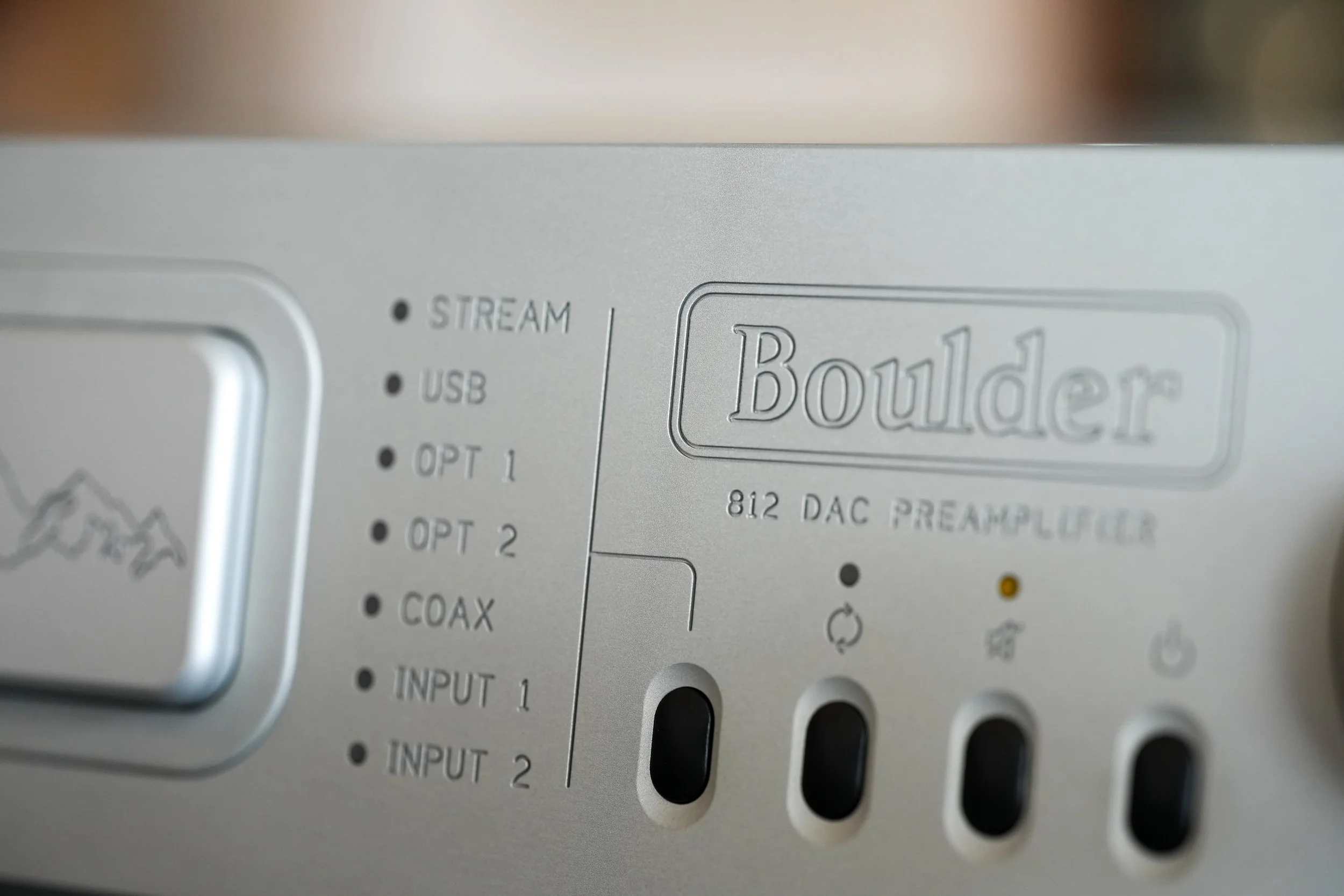 Close-up of a Boulder's 812 DAC Preamp with the brand name and model number engraved on the front panel, displaying various indicator lights and input options.