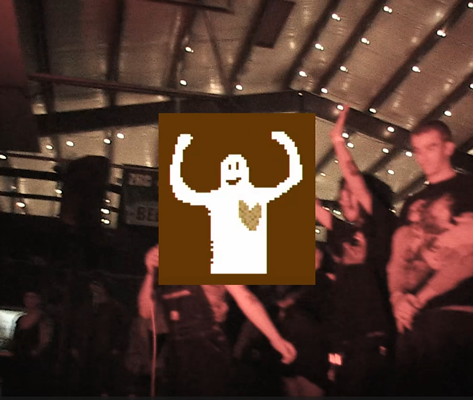People gathered in a dimly lit indoor space with string lights on the ceiling. A pixelated overlay featuring a figure with raised arms is centered on the image.