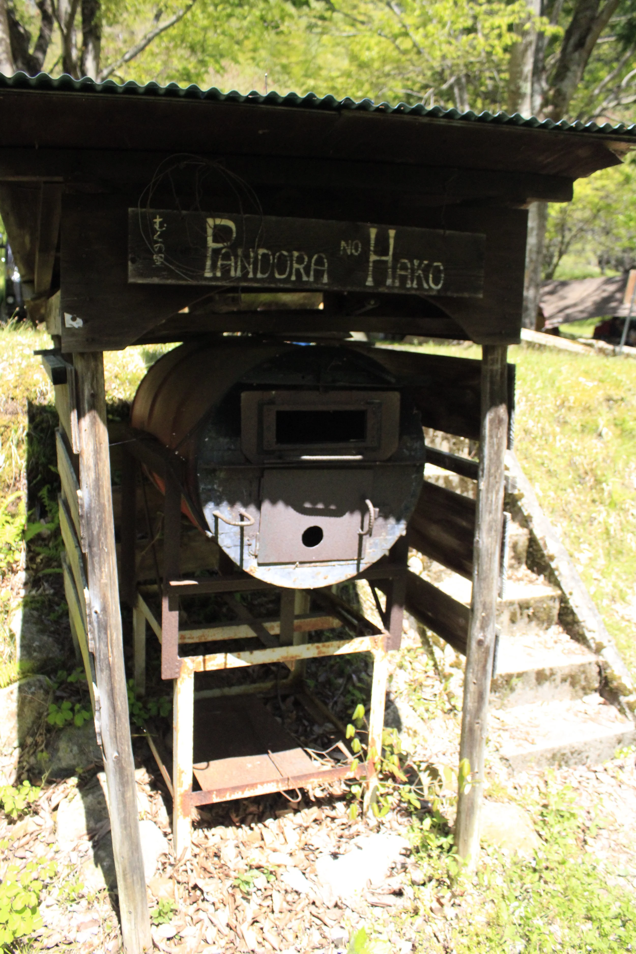 木製の囲炉裏のそばに看板があり、プンドラと番号4と書かれている。周りに木々が生えている屋外の様子。