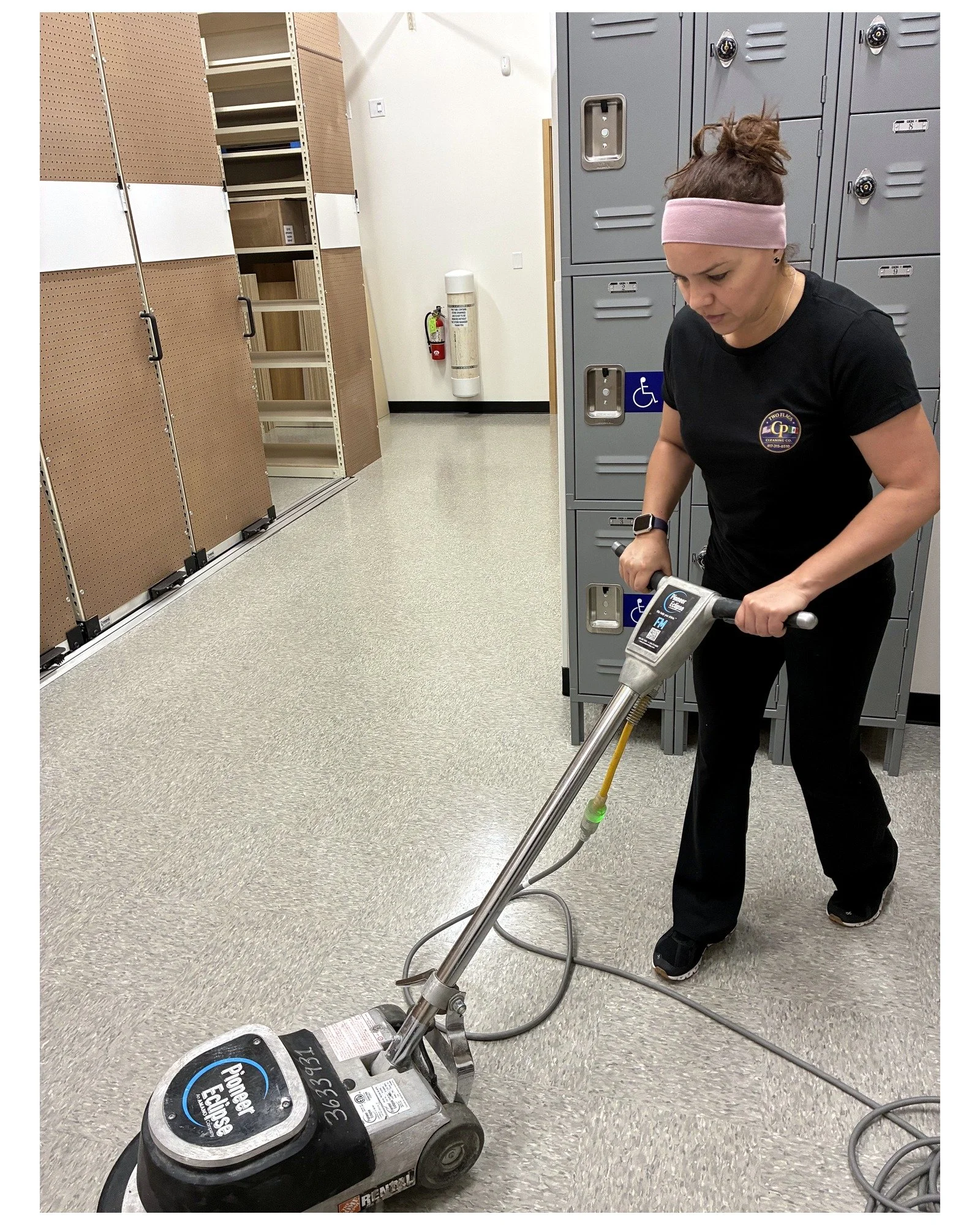 Two Flags cleaner operating a floor machine in a commercial space