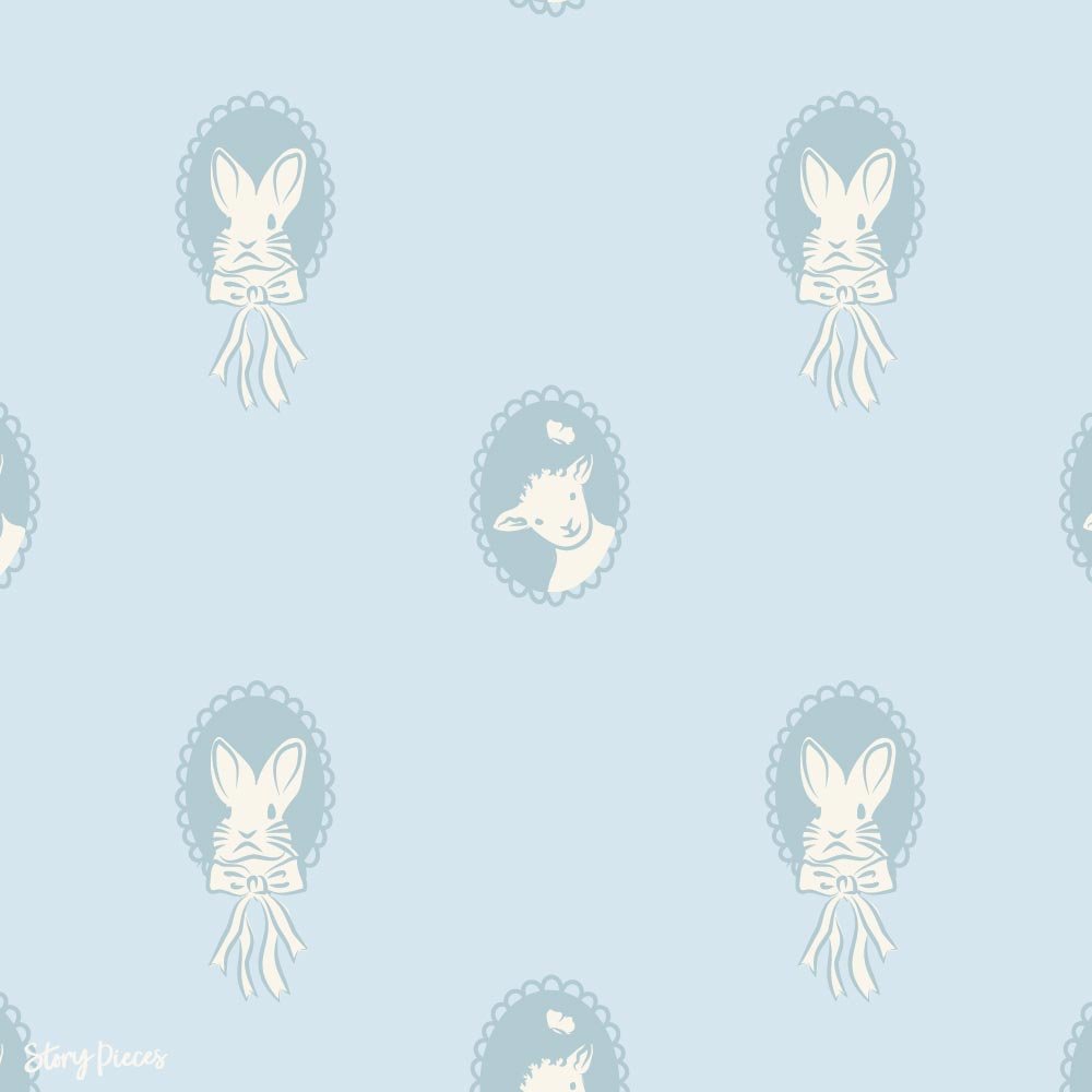 Soft blue pattern with vintage-style cameo frames featuring bunnies with bows and a lamb, a gentle storybook-inspired design for children’s textiles.